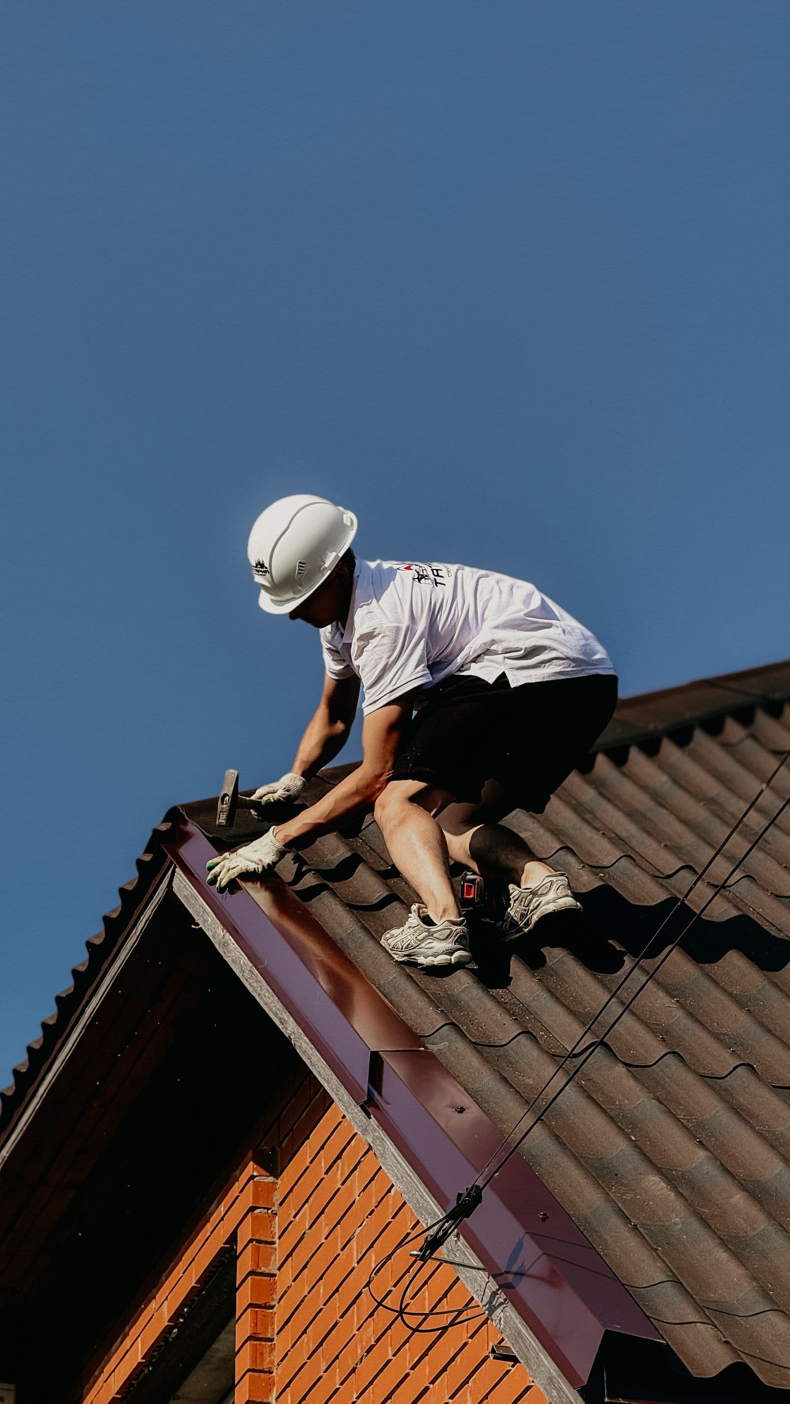 Techador trabajando en un techo bajo un cielo despejado