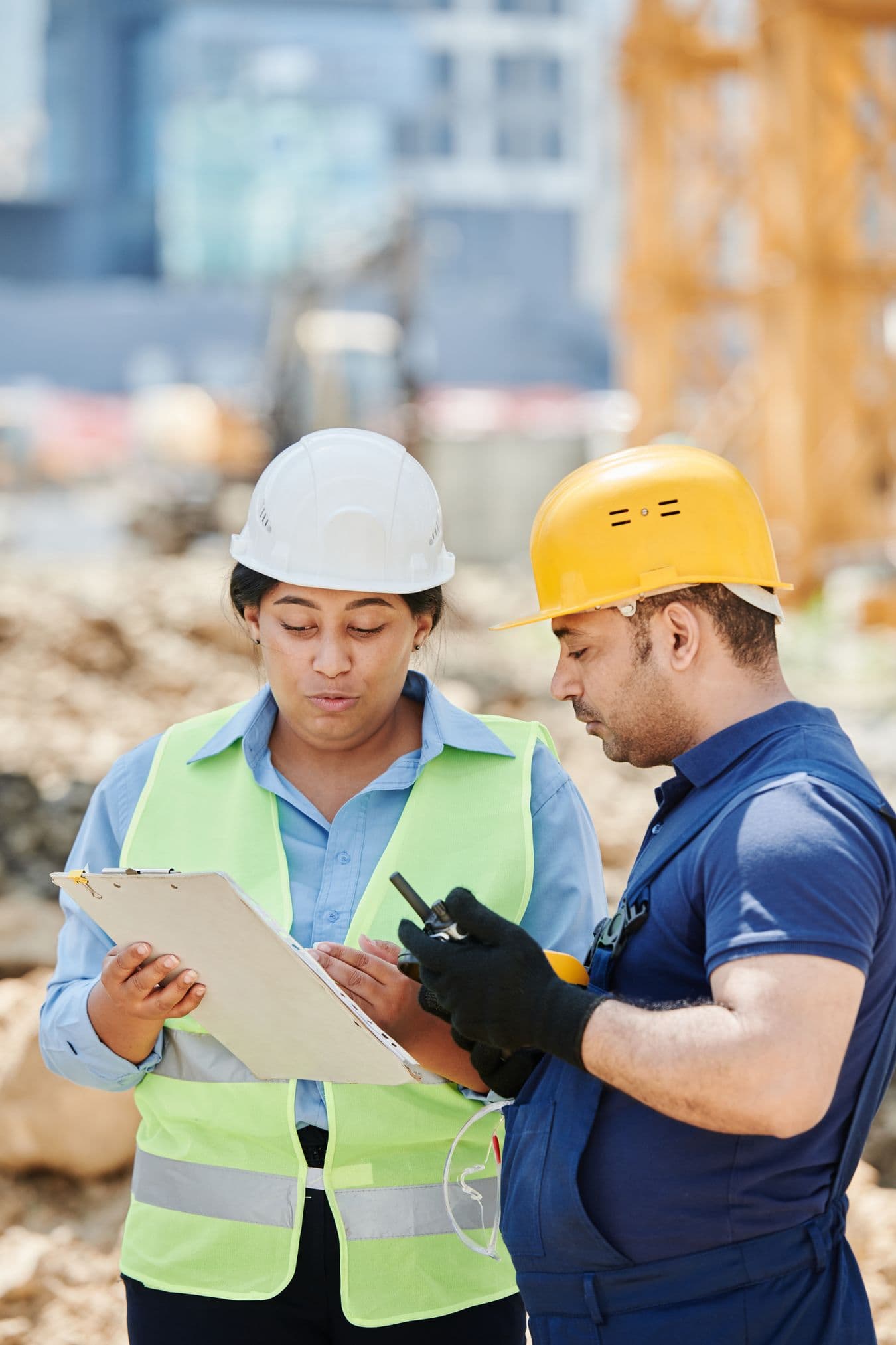 Dos trabajadores revisando un plan de trabajo en una obra